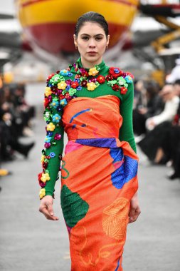 JAMAICA, NEW YORK - 06 Şubat 2020 'de DHL JFK Havalimanı' nda Jessica Minh Anhs Moda Fuarı sırasında VUNGOC ve Oğlu için podyumda bir model yürüyor 