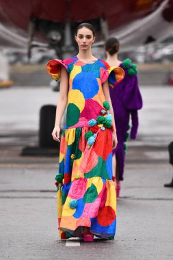 JAMAICA, NEW YORK - 06 Şubat 2020 'de DHL JFK Havalimanı' nda Jessica Minh Anhs Moda Fuarı sırasında VUNGOC ve Oğlu için podyumda bir model yürüyor 