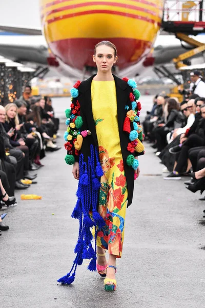JAMAICA, NEW YORK - 06 Şubat 2020 'de DHL JFK Havalimanı' nda Jessica Minh Anhs Moda Fuarı sırasında VUNGOC ve Oğlu için podyumda bir model yürüyor 