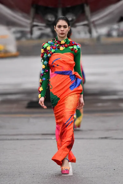 JAMAICA, NEW YORK - 06 Şubat 2020 'de DHL JFK Havalimanı' nda Jessica Minh Anhs Moda Fuarı sırasında VUNGOC ve Oğlu için podyumda bir model yürüyor 