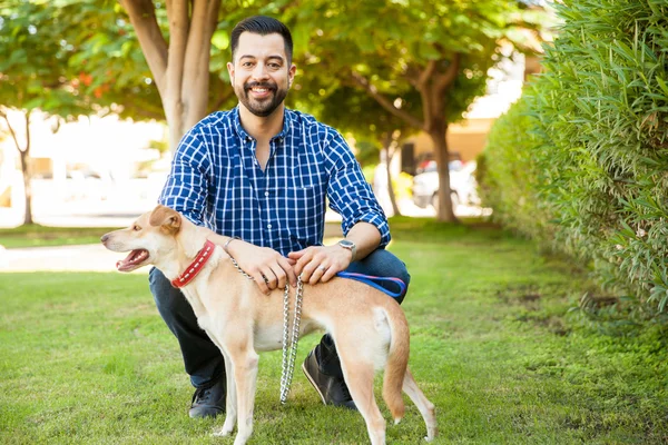 Homem agachado ao lado de seu cão — Fotografia de Stock