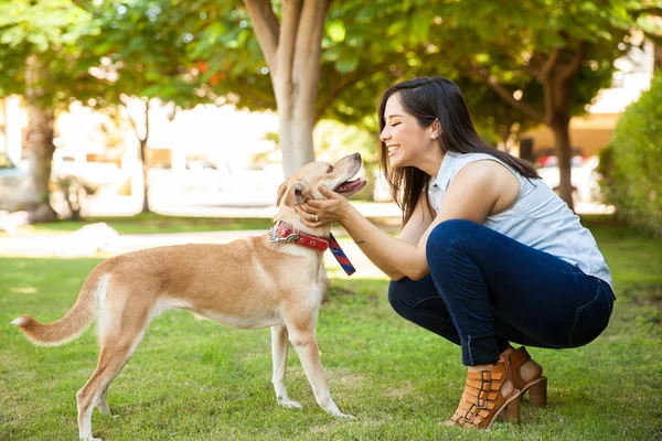 Jovem mulher acariciando seu cão — Fotografia de Stock