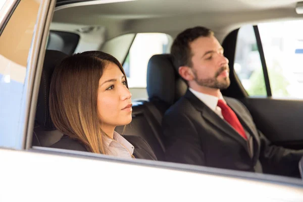 Businesswoman and man sitting in the backseats — Stock Photo, Image