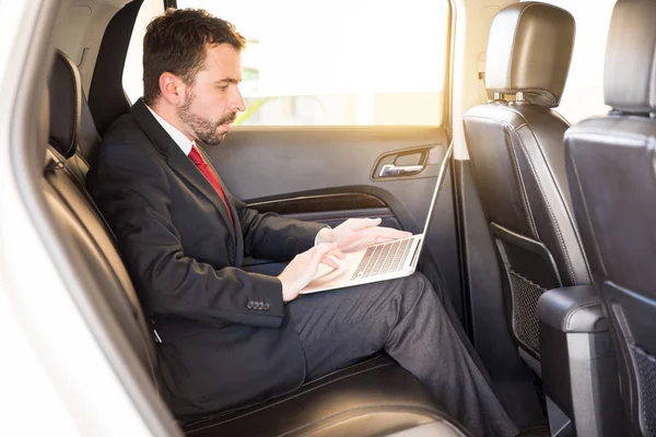 Biznesmen korzysta z laptopa w samochodzie — Zdjęcie stockowe