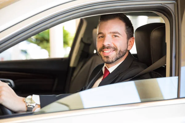 Driver in a suit looking out the car — Stock Photo, Image