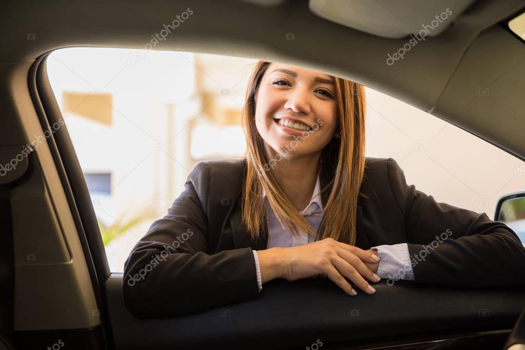 driver in a suit leaning on a car door 
