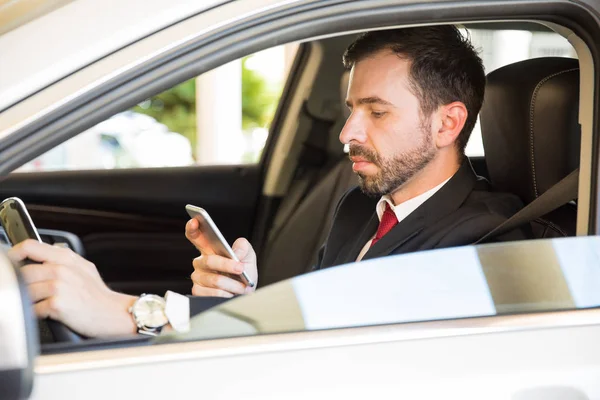 Joven con un traje conduciendo un coche — Foto de Stock