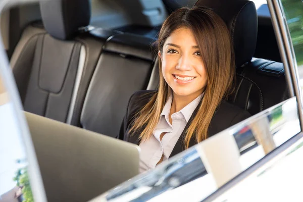 Mujer de negocios en coche y el uso de un ordenador portátil — Foto de Stock