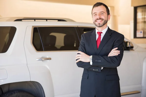 Vendedor em um terno tentando vender carro — Fotografia de Stock