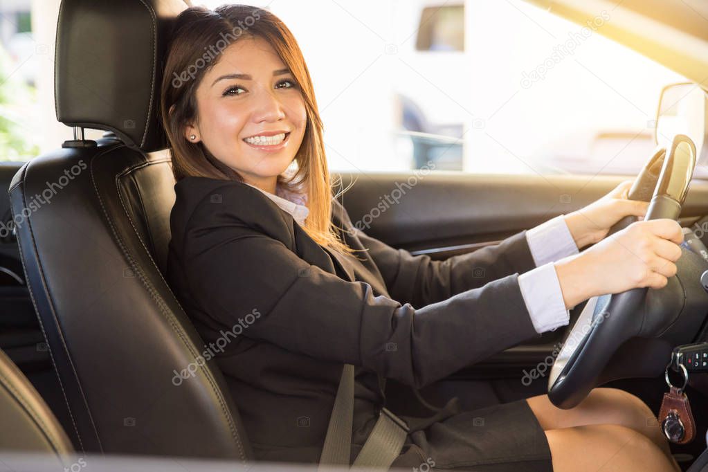 Hispanic woman in a suit driving