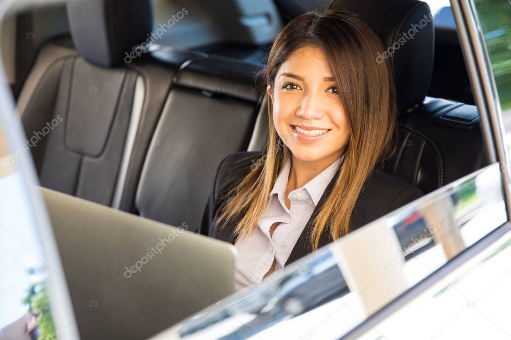 businesswoman in car and using a laptop
