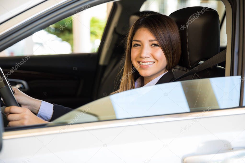brunette in a suit driving a car 
