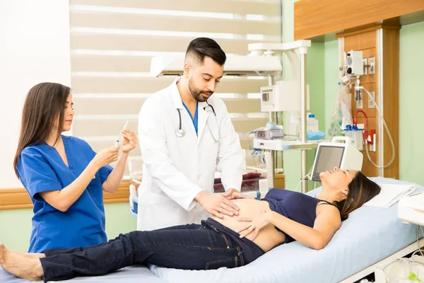 Doctors  taking care of a young pregnant woman — Stock Photo, Image