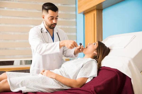 Arzt untersucht die Kehle eines Patienten — Stockfoto