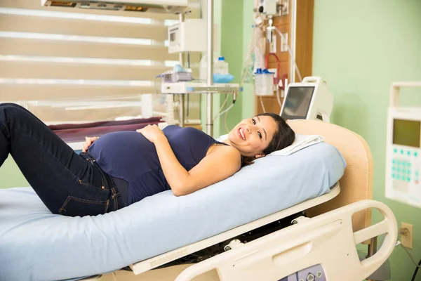 Terhes nő feküdt egy kórházi ágyon — Stock Fotó