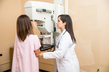 Doctor and patient during mammogram clipart