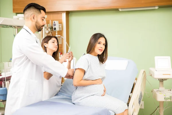 Médicos dando tiro para mulher grávida — Fotografia de Stock