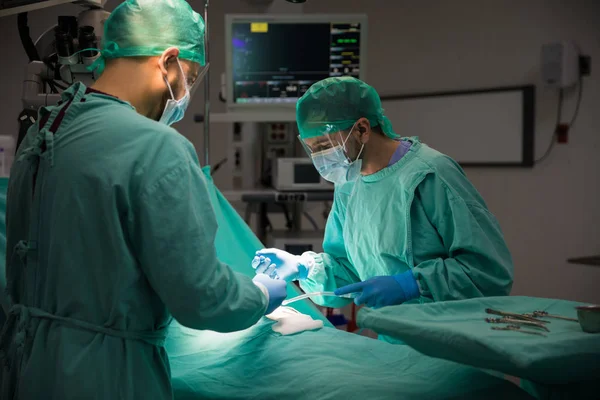 Cirurgião operando feridas no paciente — Fotografia de Stock