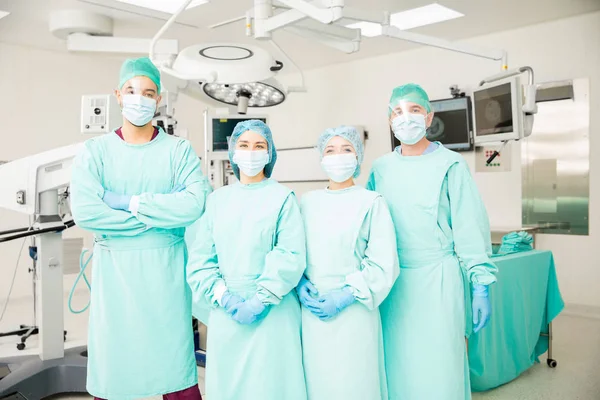 Equipe de cirurgiões em pé na sala de cirurgia — Fotografia de Stock