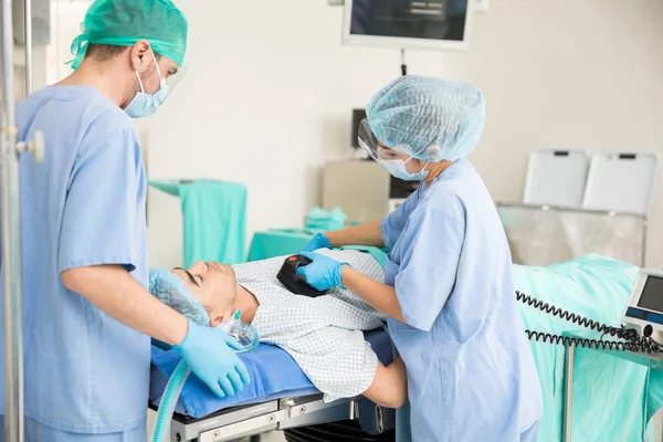 Doctors giving defibrilation to patient — Stock Photo, Image