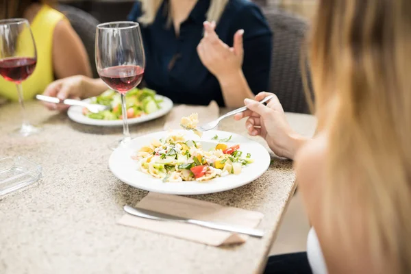 Primo piano di una donna che mangia con gli amici — Foto Stock