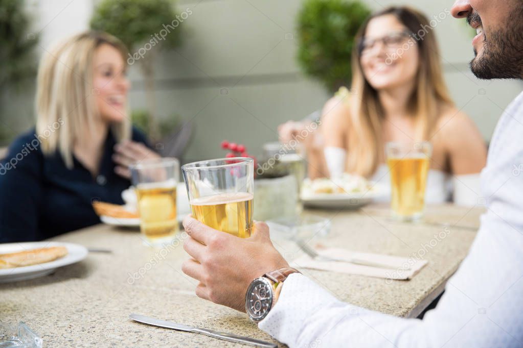 Man drinking beer with some friends