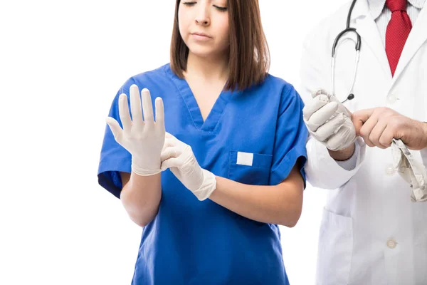 Enfermera y médico poniéndose guantes — Foto de Stock