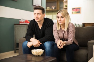 Young couple watching a thriller clipart