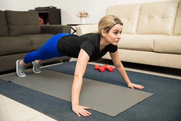 Kvinde laver push ups derhjemme - Stock-foto