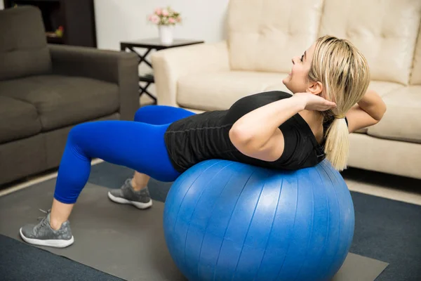 Mulher fazendo crunches em uma bola de estabilidade — Fotografia de Stock