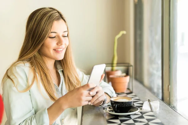 Jeune femme utilisant un smartphone — Photo