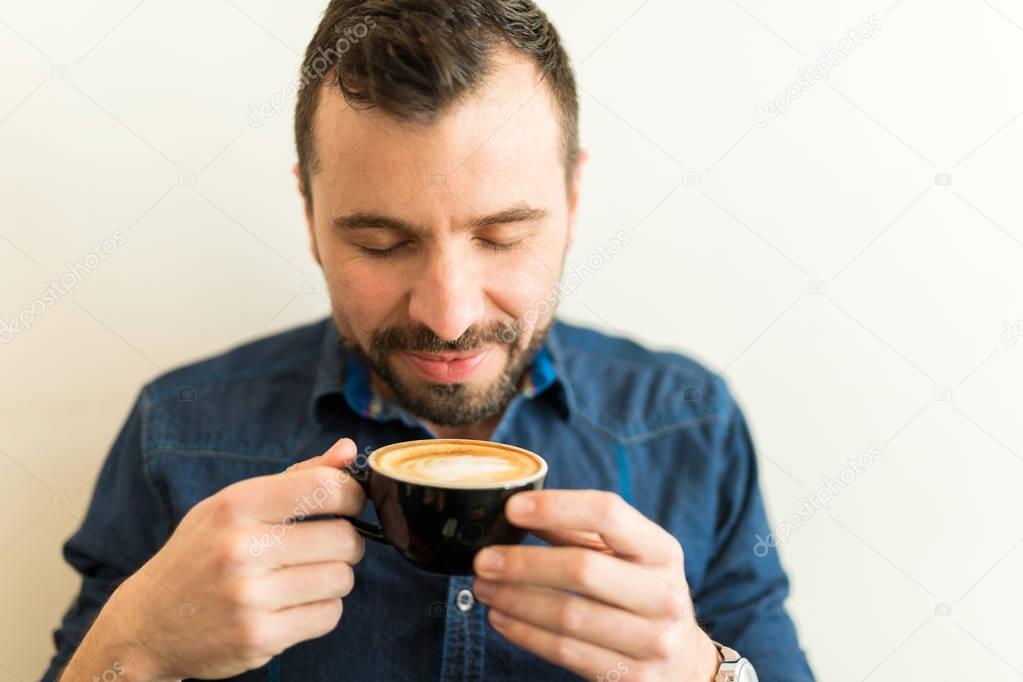 Man smelling cup of coffee