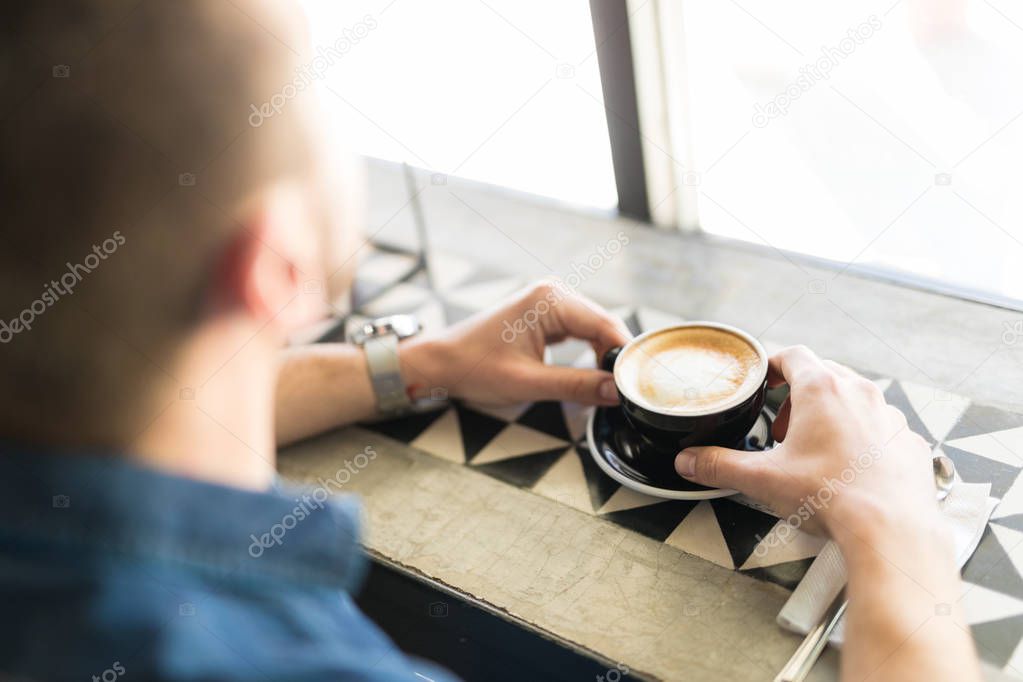 Man drinking cup of cappuccino