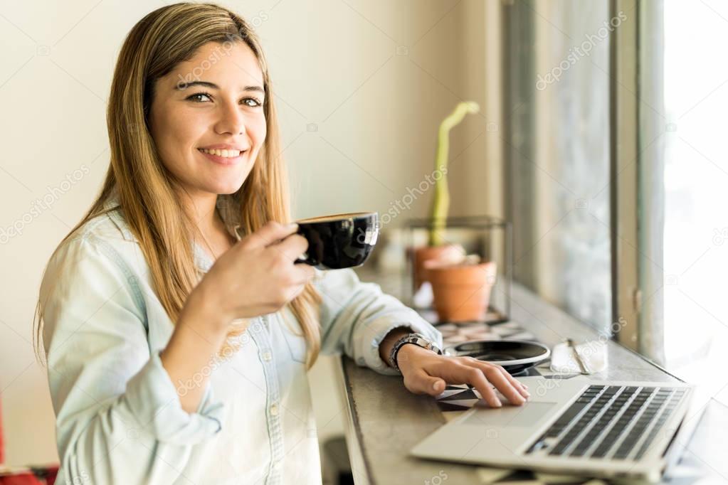 Young woman drinking cup of coffee 