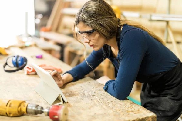 Kadın marangozluk içinde çalışmaya bakıyor — Stok fotoğraf