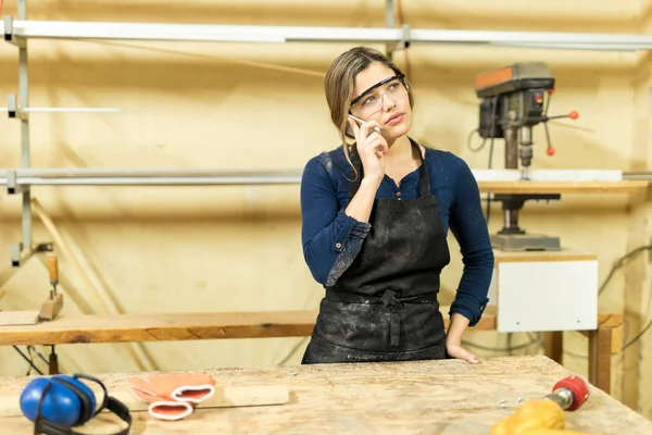 Carpinteiro feminino fazendo telefonema — Fotografia de Stock