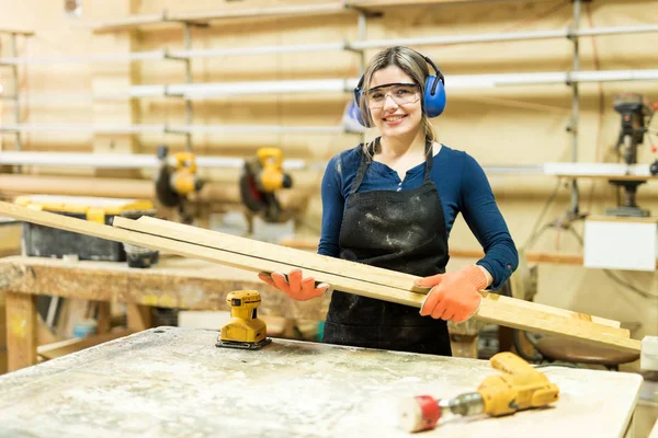 Carpintero llevando racimo de tablas de madera — Foto de Stock