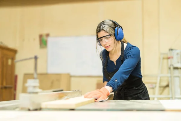 Carpinteiro feminino usando auriculares — Fotografia de Stock