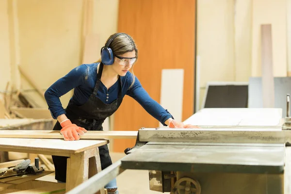 Carpenter wearing earmuffs and protective glasses — Stock Photo, Image