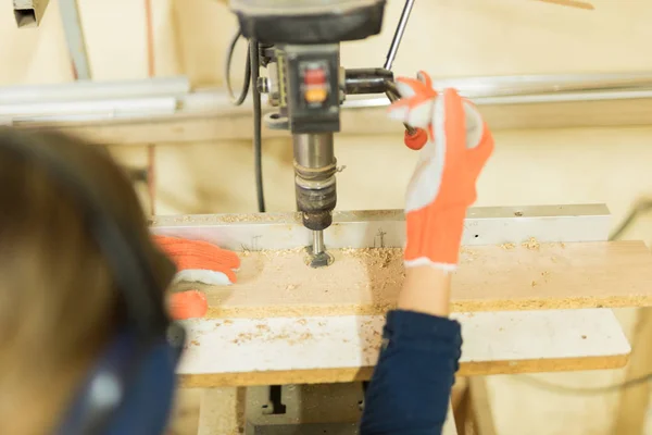 Female carpenter drilling some holes — Stock Photo, Image