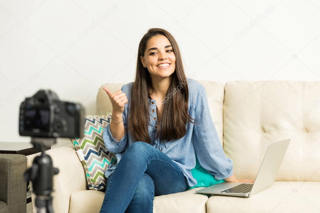 Cute girl giving a thumb up on her vlog