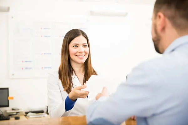 Receptionist consegna i risultati al paziente — Foto Stock