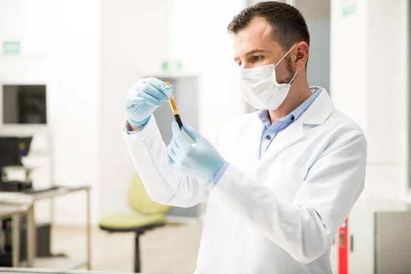 Químico masculino mirando una muestra de sangre — Foto de Stock