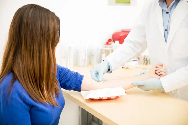 Doctor putting adhesive bandage on woman — Stock Photo, Image