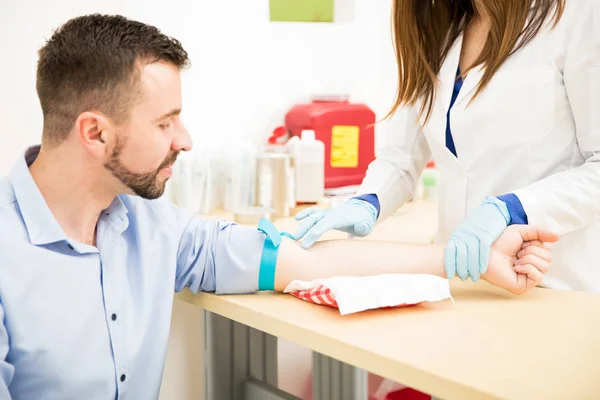 Medico in cerca di una vena per il prelievo di sangue — Foto Stock