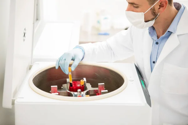 Químico masculino usando centrífuga em um laboratório — Fotografia de Stock