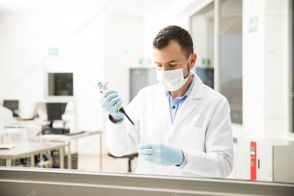 Chemist using a pipette at work
