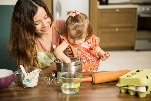 Menina ajudando mãe preparar bolo — Fotografia de Stock