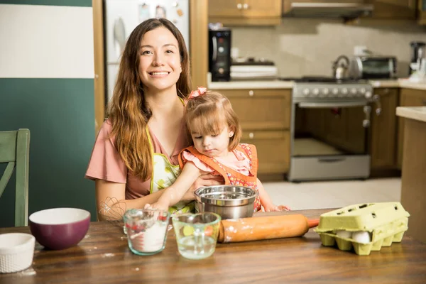 Девушка помогает матери готовить торт — стоковое фото