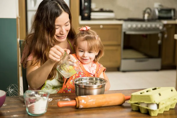 Ragazza aiutando la madre a preparare la torta — Foto Stock